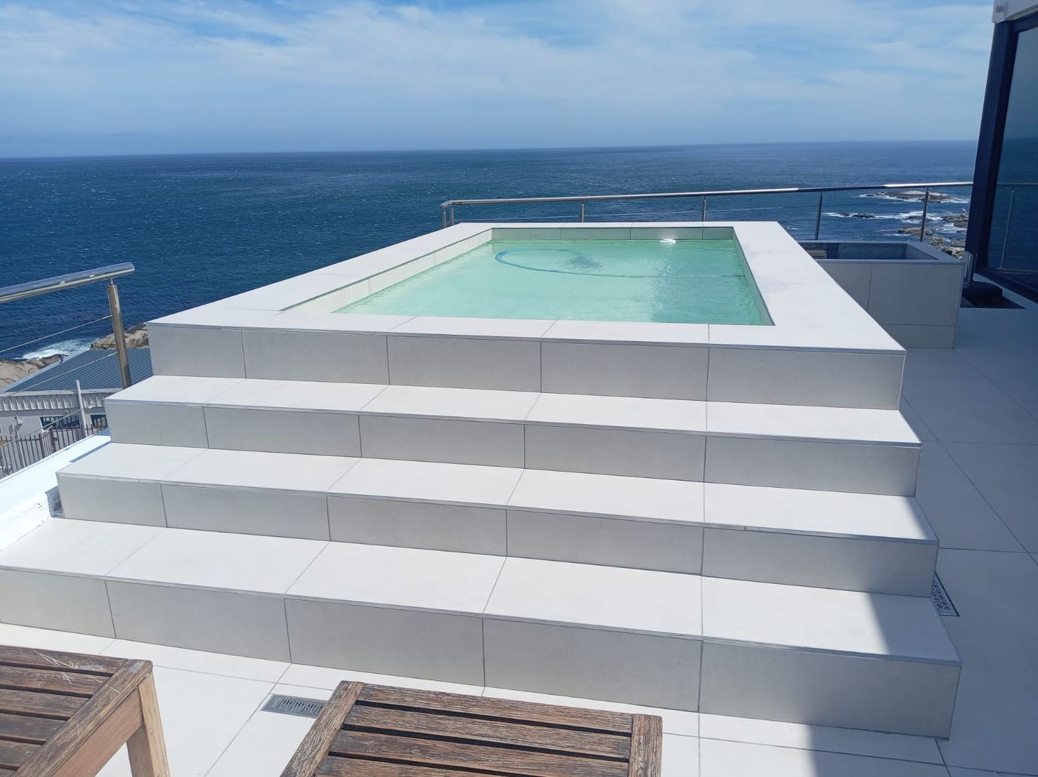 Seafoam infinity pool on a rooftop terrace overlooking the ocean